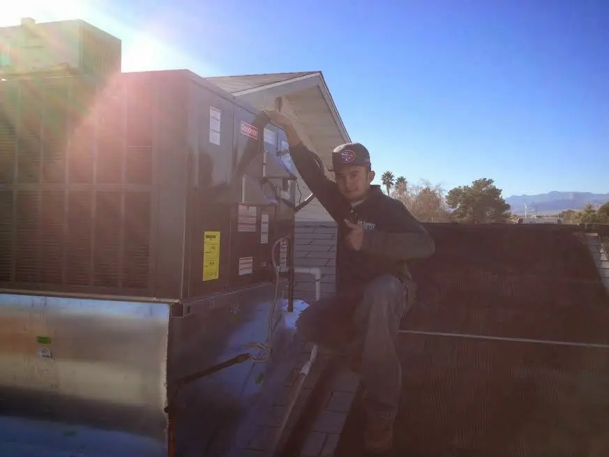 HVAC technician performing HVAC Inspection on a rooftop unit in Freeport